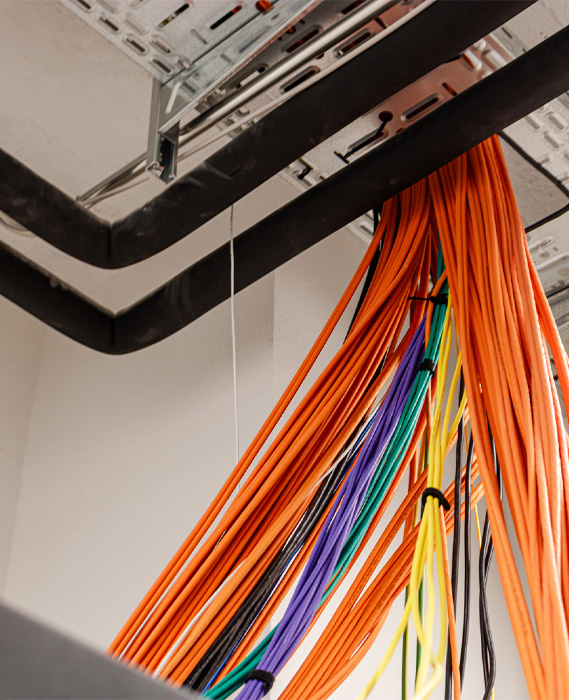 bunches of colorful cables running from the ceiling to different places (Photo)